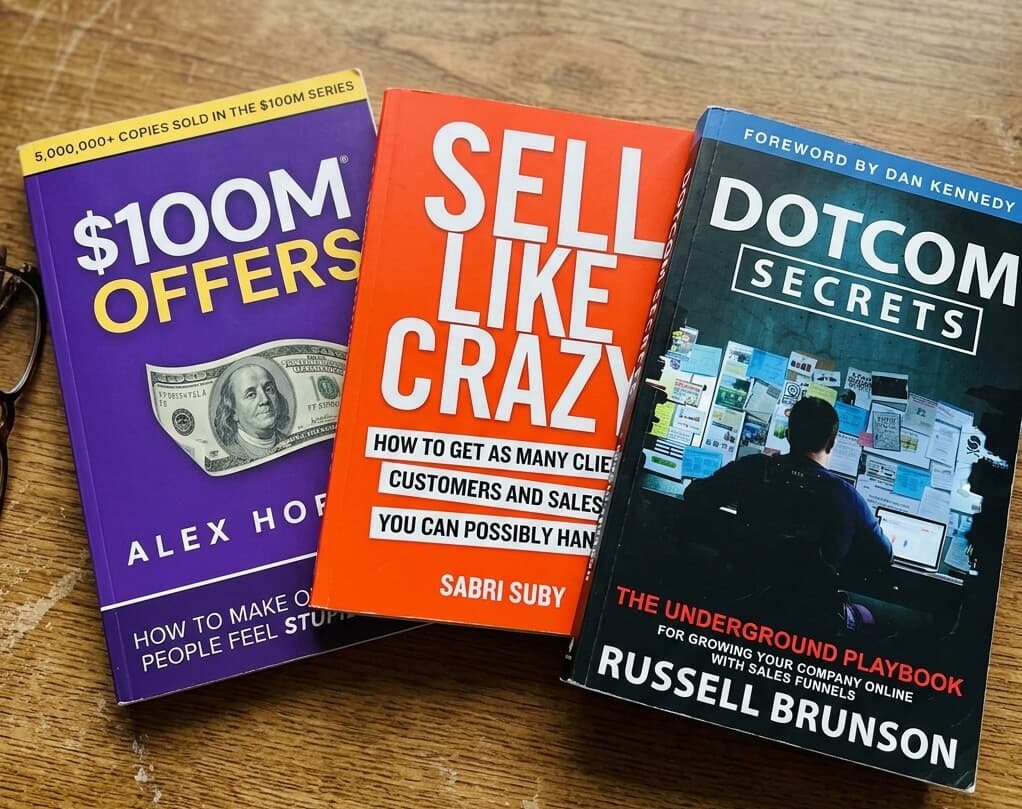 $100M Offers, Sell Like Crazy, and DotCom Secrets — the three books side by side